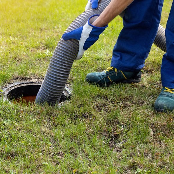 man pumping out house septic tank. drain and sewage cleaning service. copy space